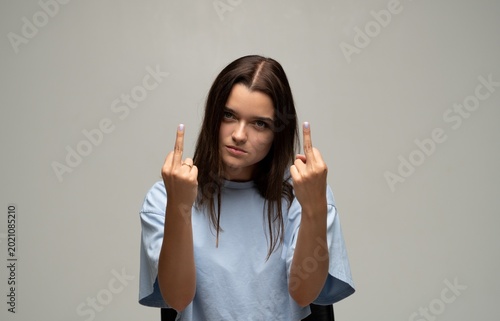 Foto Young woman showing middle finger gesture expressing anger, defiance and disresp
