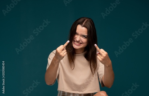 Картината върху платно Young woman showing middle finger gesture, expressing defiance, frustration, and