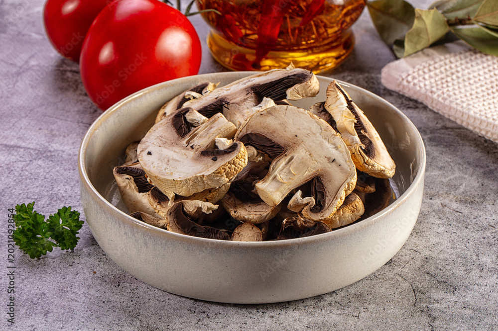 Fototapeta premium Dried mushrooms in a bowl with tomatoes and cooking ingredients