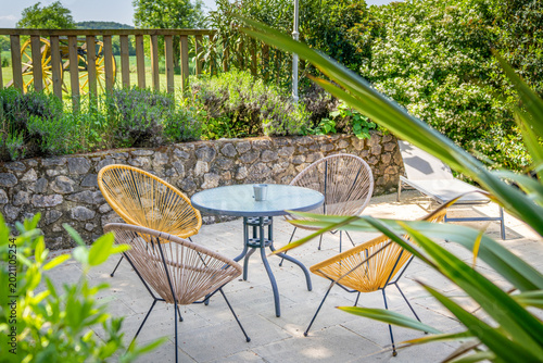 Fotografi Un salon de jardin dans la nature, il y à 4 chaises autour d'une table au milieu