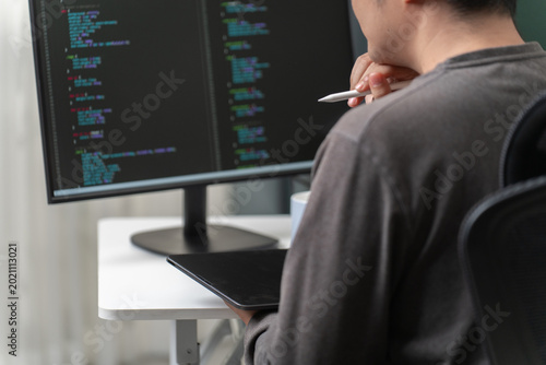 Obraz na płótnie Software Developer Working on Code at Computer with Multiple Monitors