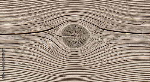 Macro closeup of weathered light wood grain featuring a prominent central knot with intricate circular patterns and aged rustic texture for organic background
