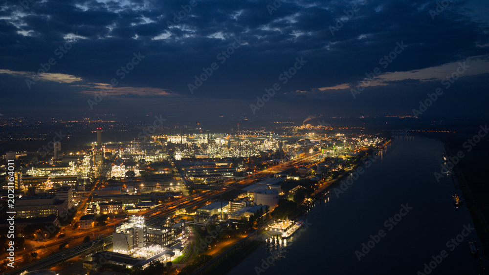 Fototapeta premium Night aerial view of industrial complex along river