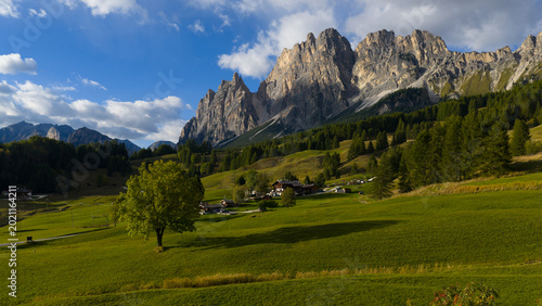 Foto Dolomites mountain landscape showing green valley and alpine village
