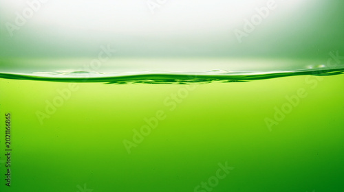Close up texture of green Chartreuse water waves on white background.
