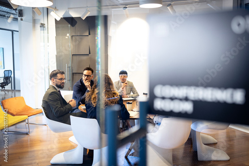 Business professionals having meeting in modern conference room, discussing strategy and collaborating