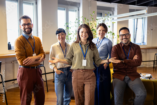 Diverse business team smiling at camera, showing professionalism and teamwork in a modern office workplace setting