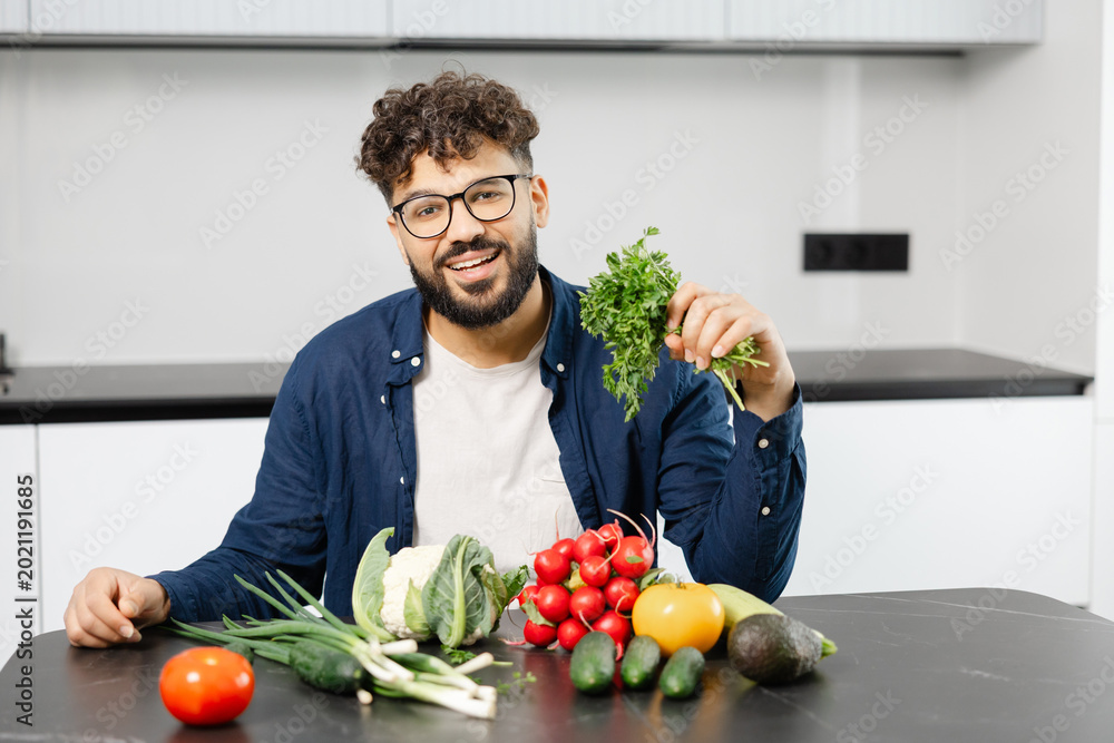 Fototapeta premium Man preparing healthy meal with fresh vegetables