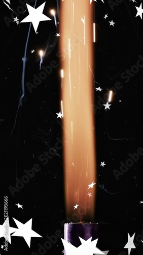 Vertical video: Sparkler igniting on purple tube, flame rising with sparks, stars drifting for demo
