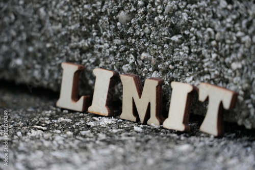 Bild auf Leinwand Wooden letters spelling out the word LIMIT on a textured surface