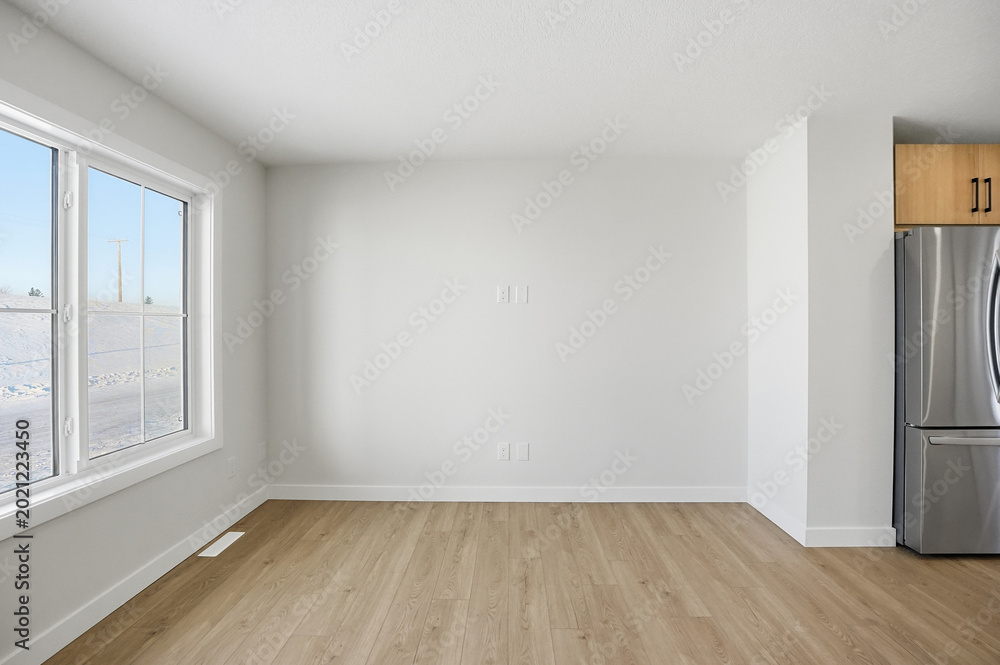 Fototapeta premium Large empty room with a window and a silver refrigerator