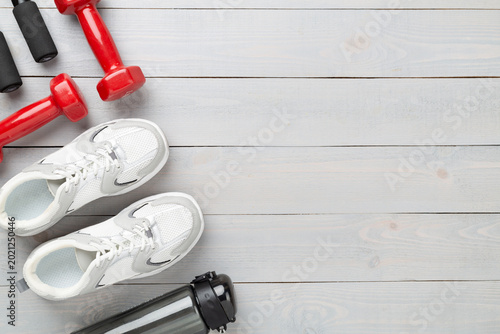 Set of sports equipment on wooden background, top view