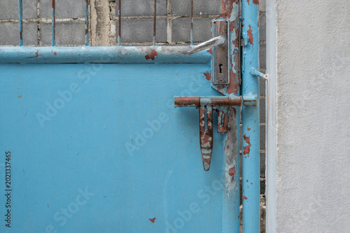 Unlocked Blue Metal Gate with Rusty Bolt Latch