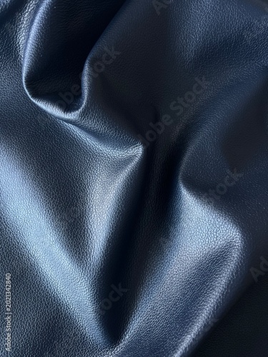 Dark blue leather texture background with soft folds and premium grain detail, featuring elegant luxury material, rich fabric surface and modern minimalist aesthetic in close-up view.