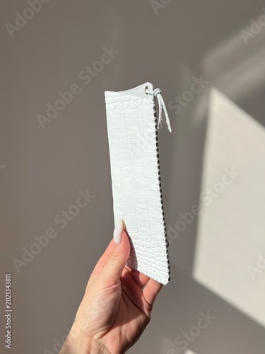 Minimalist white leather glasses case with crocodile texture, handmade craftsmanship and elegant modern design in soft natural light.