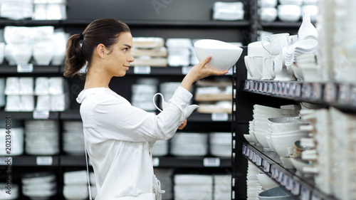 Customer browsing kitchenware and tableware in contemporary home store. Concept consumer lifestyle and shopping experience.
