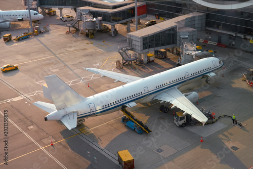 Schilderij op canvas Commercial airplane is connected via a hose for boarding passengers, and ready f