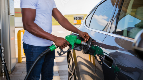Photos Man refuels car at gas station