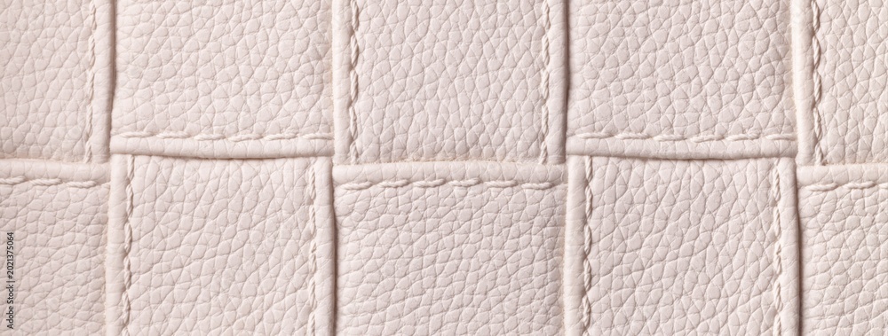Fototapeta premium Texture light beige leather background with quilted stitched pattern, macro. Abstract pastel nude upholstery surface