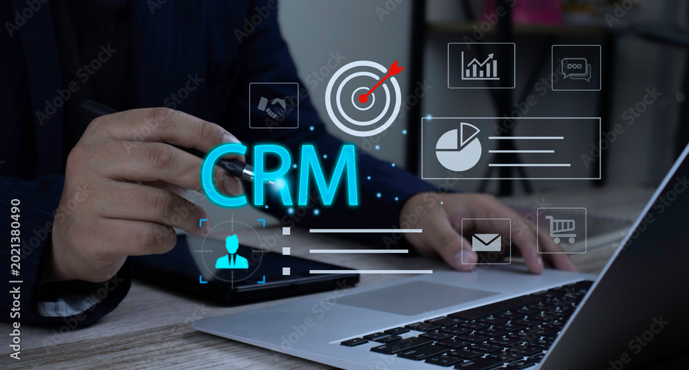 Naklejka premium Businessman using laptop for digital business strategy. Platform CRM interface icons showing customer data management, communication tracking, and sales performance.