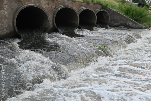 Canvas Print Wastewater Discharge Flowing from Concrete Drainage Pipes into Canal