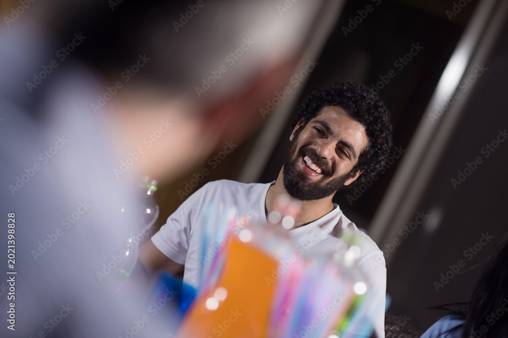 Fototapeta premium Middle Eastern man smiling during Eid Ramadan iftar dinner with modern family at home