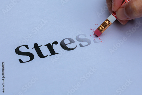 Картината върху платно Hand erasing the word stress with a pencil eraser on white paper with copy space