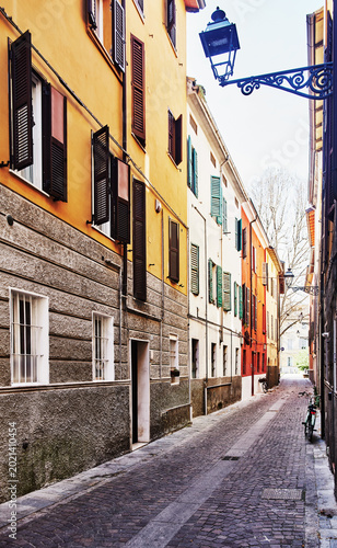 narrow cobblestone street lined with colorful, historic buildings, characteristic of the city of Parma, Italy, Europe 