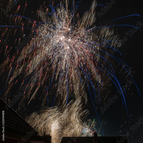 Colorful Fireworks Over City Rooftops Night