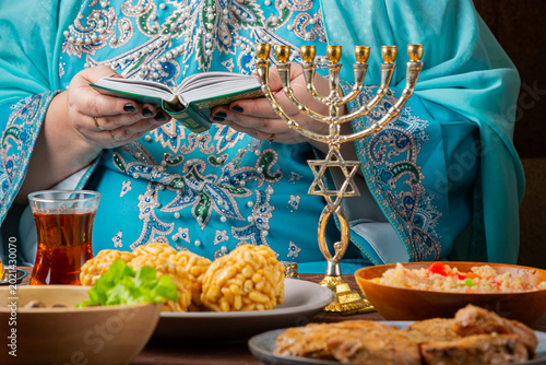 Foto A Jewish woman prays from the siddur at a table