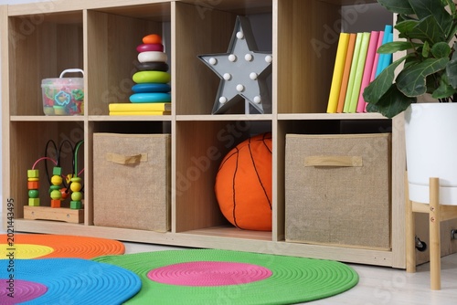 Quadro su tela Shelving unit with toys, books and decor in child's room, closeup