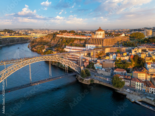Drone view of Mosteiro da Serra do Pilar in Vila Nova de Gaia near Porto, Portugal, with a tram on Dom Luis I Bridge at sunset
