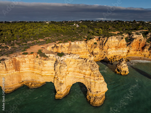 Aerial view of Praia da Marinha beach in Algarve, Portugal, with ocean cliffs, sea stacks and steep rock walls.