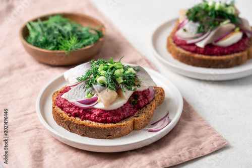 Open sandwich with herring beetroot mousse egg dill and green onion, traditional Scandinavian cuisine appetizer concept