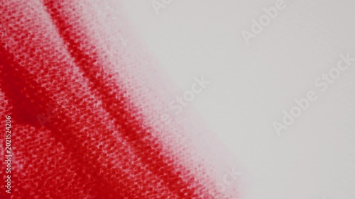 Close up of red watercolour drawing paints on paper. Artist draws with a brush, liquid analog effects for background with copy space for text in center. 