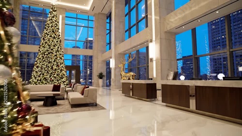 A beautifully designed office interior features a luxury sofa, wood floor, and large window alongside a festive Christmas tree with elegant decorations in an empty indoor room