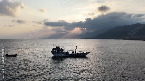 Traditional fishing boat sailing on a calm sea at sunset, Socotra island