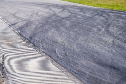Foto High angle view of black rubber tire skid marks on asphalt racing track with whi