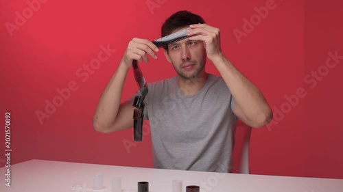 Male demonstrates small device assembly. Calm manual tutorial of gadget construction. Professional demonstration of assembling tiny electronic device on simple white table