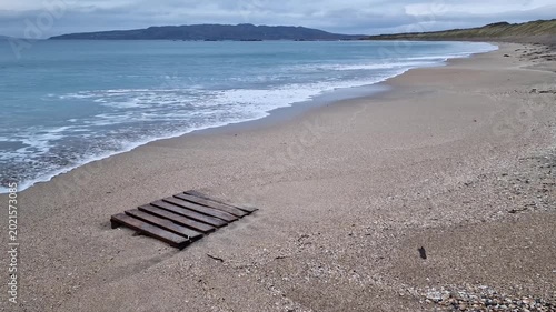 Wooden palette on a beach, litter on the beach