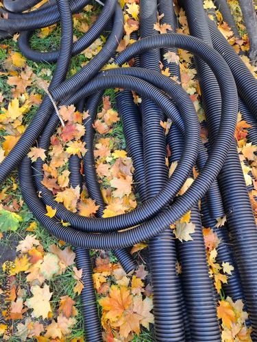 Foto Black corrugated plastic pipes lie on the ground