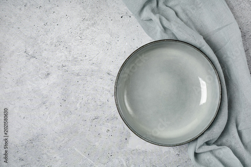 Top view of empty bowl on grey stone table. Minimalist food background for culinary blog, social media posts, cafe branding. Top view.