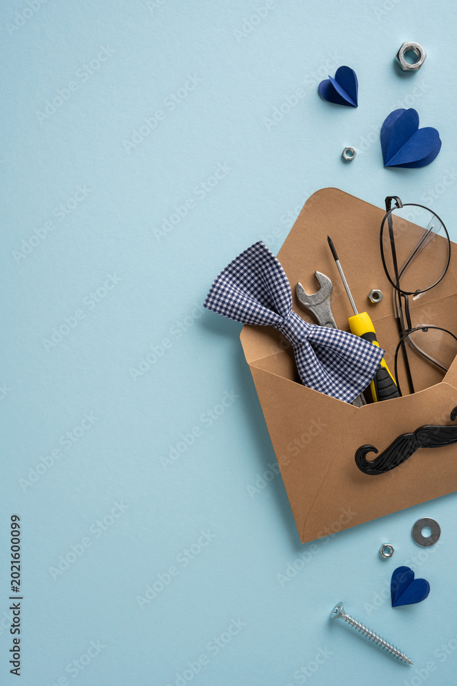 Fototapeta premium Father's Day gift vertical envelope with tools, bow tie and glasses for a handyman dad