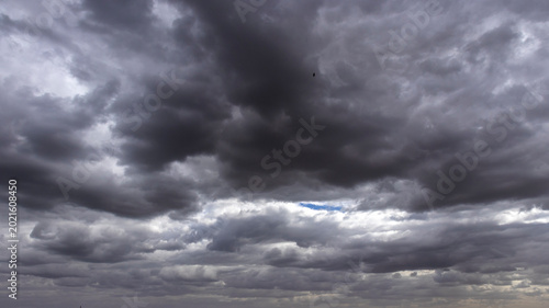 Dramatic view of heavy, dark storm clouds filling the sky over Brazil. The dense, gray clouds create a moody and powerful atmosphere, 