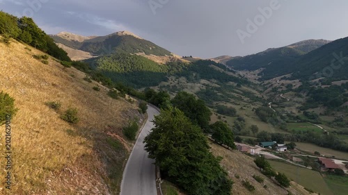 Scenic winding road through lush mountains in the golden light of late afternoon sun