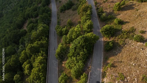 Winding mountain road reveals nature's beauty under the soft glow of sunset in a tranquil landscape