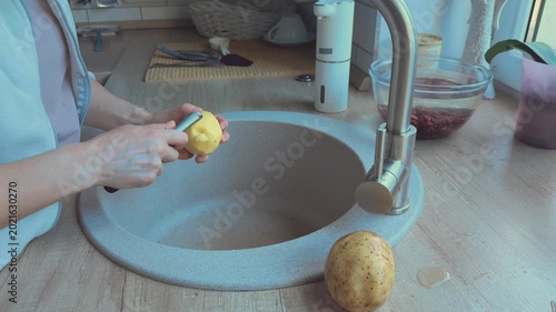 Potato eyes removed with knife cleaning vegetable before cooking meal. 