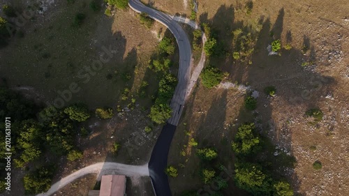 Winding road through serene landscape under golden sunlight in a peaceful countryside setting