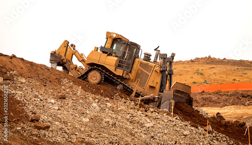 Cuadro en lienzo A bulldozer pushing dirt on a hill at a construction site