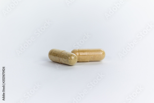 Fotografie Two Herbal Medicine Capsules Filled with Natural Brown Powder Isolated on White
